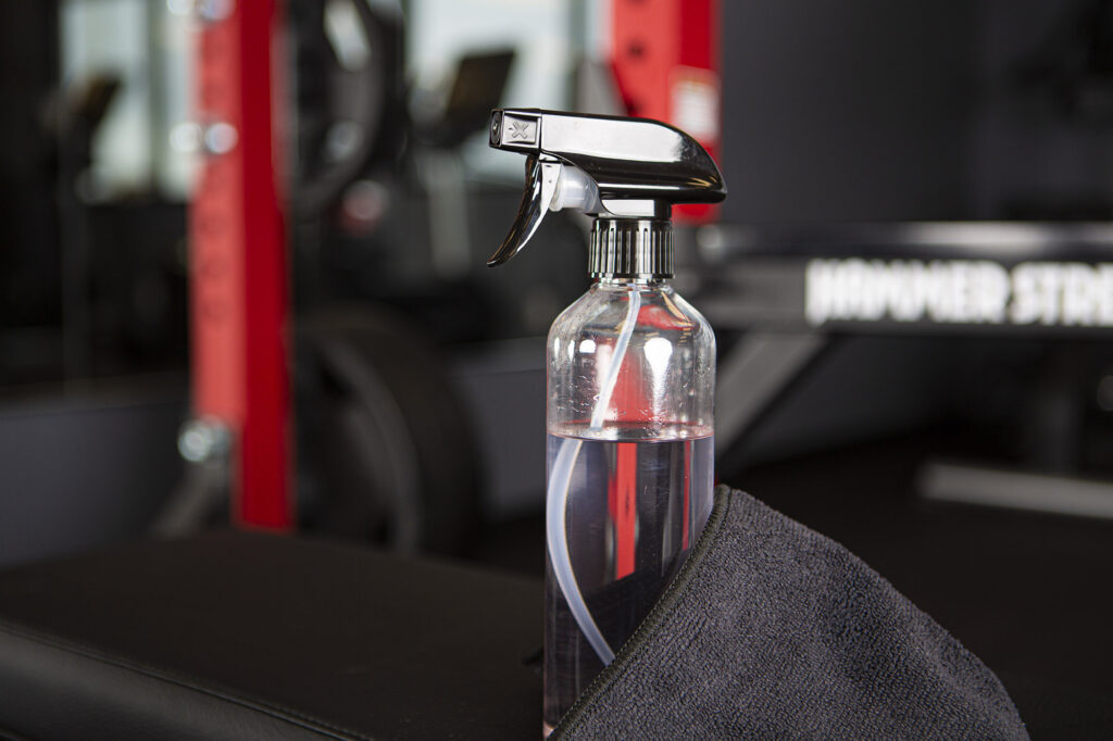 Black towel and clear spray bottle containing cleaning solution