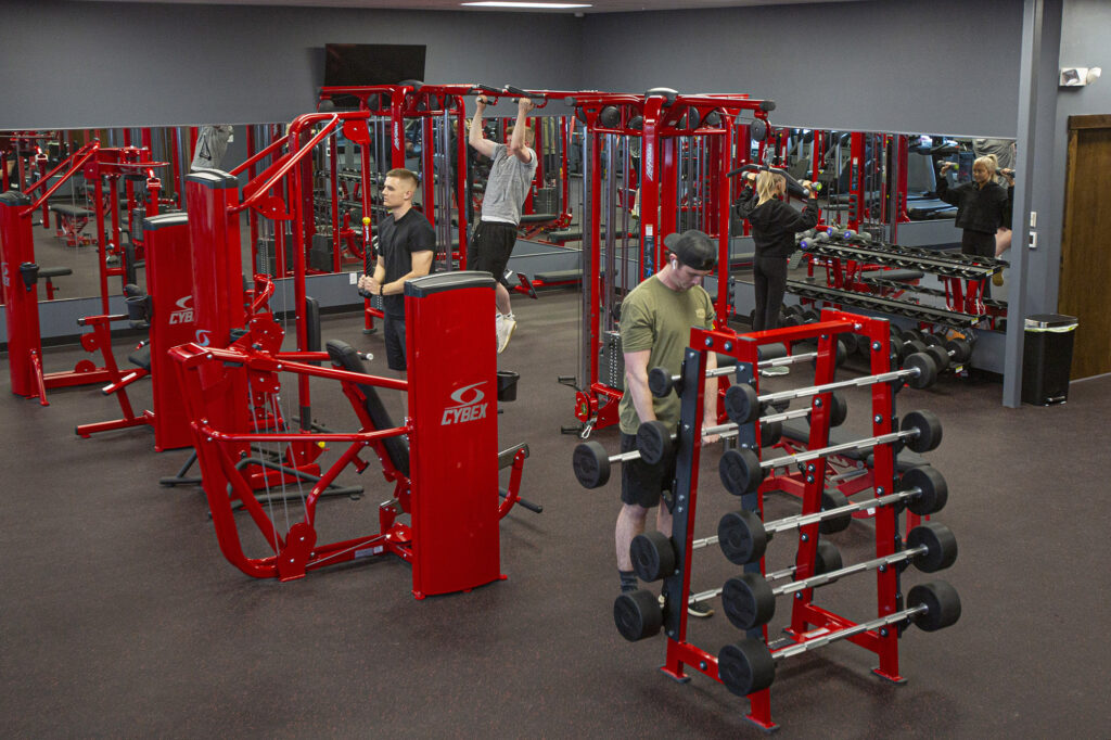 A small group of people exercising in a weight room